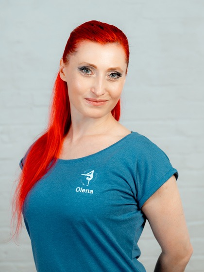 Frau mit roten Haaren und blauem T-Shirt lächelt in Kamera
