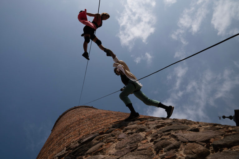 Ein Mann und eine Frau machen Vertical Dance an einer Hauswand im Freien